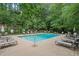 Community pool surrounded by lounge chairs and lush green trees at 3663 Essex Ave # 29, Atlanta, GA 30339