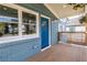 Inviting front porch featuring painted blue brickwork, natural wood deck, and a pop of color at 75 Mayson Ne Ave, Atlanta, GA 30307