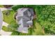 An aerial view of the home highlighting its roof, landscaping, deck, and surrounding trees at 10830 Carrara Cv, Alpharetta, GA 30022