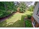 Well-maintained backyard with lush lawn, mature trees, and manicured landscaping at 10830 Carrara Cv, Alpharetta, GA 30022