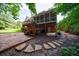 Spacious backyard with stone walkway, lush greenery, and a multi-level deck at 10830 Carrara Cv, Alpharetta, GA 30022