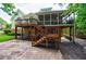 Multi-tiered backyard with wooden stairs, stone patio, and serene green surroundings at 10830 Carrara Cv, Alpharetta, GA 30022