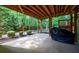 Covered patio area with trees, greenery, and a barbecue grill at 10830 Carrara Cv, Alpharetta, GA 30022