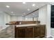 Finished basement bar area with sink, wooden bar, and stylish tile flooring at 10830 Carrara Cv, Alpharetta, GA 30022