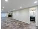 Basement with tiled floors leads to a bathroom and bar area for entertaining at 10830 Carrara Cv, Alpharetta, GA 30022