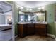 A corner bathroom vanity featuring wood cabinets, a white countertop, and modern lighting at 10830 Carrara Cv, Alpharetta, GA 30022