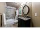 Bathroom with tiled walk in shower, granite countertop, and classic black oval mirror at 10830 Carrara Cv, Alpharetta, GA 30022