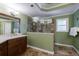 Green bathroom with a double vanity, large walk-in shower and light tile floors at 10830 Carrara Cv, Alpharetta, GA 30022
