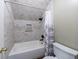 Bathroom shower and toilet with stone-look tile and modern fixtures at 10830 Carrara Cv, Alpharetta, GA 30022