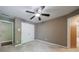 Neutral bedroom with a ceiling fan, closet, and a door leading to the bathroom at 10830 Carrara Cv, Alpharetta, GA 30022