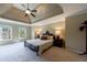 Spacious bedroom with tray ceiling, ceiling fan, carpet, and two windows for natural light at 10830 Carrara Cv, Alpharetta, GA 30022