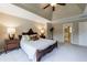 Elegant bedroom with a detailed wooden bed frame, soft carpet, and ample natural light from windows at 10830 Carrara Cv, Alpharetta, GA 30022