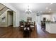 Spacious dining area featuring hardwood floors, a chandelier, access to a kitchen, and staircase in view at 10830 Carrara Cv, Alpharetta, GA 30022