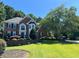 Beautiful two-story brick home with manicured lawn and mature trees on a sunny day at 10830 Carrara Cv, Alpharetta, GA 30022
