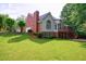 Expansive backyard view of a brick home with a screened porch and lush green lawn at 10830 Carrara Cv, Alpharetta, GA 30022