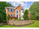 Elegant brick home with a well-maintained lawn, stone retaining wall, and lush landscaping at 10830 Carrara Cv, Alpharetta, GA 30022