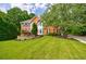 Beautiful brick home showcasing a lush front yard, mature trees, and a well-kept landscape at 10830 Carrara Cv, Alpharetta, GA 30022