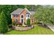 Well-manicured front yard, mature trees, and landscaping enhancing the curb appeal of this brick home at 10830 Carrara Cv, Alpharetta, GA 30022