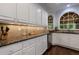 Kitchen featuring white cabinets, stainless steel appliances, granite countertops, and arched windows for natural light at 10830 Carrara Cv, Alpharetta, GA 30022