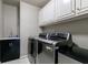 Laundry room equipped with modern washer and dryer units and ample storage at 10830 Carrara Cv, Alpharetta, GA 30022