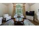 Inviting living room featuring a large window, hardwood floors, and comfortable seating arrangements at 10830 Carrara Cv, Alpharetta, GA 30022