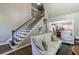 Cozy living room with staircase, comfortable sofa, and open access to the dining and kitchen area at 10830 Carrara Cv, Alpharetta, GA 30022