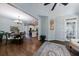 Open-concept living space with hardwood floors, dining area, kitchen, and access to the sunroom at 10830 Carrara Cv, Alpharetta, GA 30022
