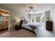 Cozy main bedroom with neutral tones, ceiling fan, and ensuite bathroom access at 10830 Carrara Cv, Alpharetta, GA 30022