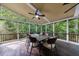 Charming screened porch with wooded views, a ceiling fan, and dining set at 10830 Carrara Cv, Alpharetta, GA 30022
