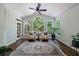 Cozy sunroom with large windows, comfortable seating, a ceiling fan, and natural light with hardwood floors at 10830 Carrara Cv, Alpharetta, GA 30022