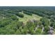 An aerial view of the golf course and country club nestled amongst lush greenery and trees at 110 Westchester Way, Alpharetta, GA 30005