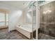 Bathroom showcasing a soaking tub, a separate shower with modern fixtures, and tiled floors at 110 Westchester Way, Alpharetta, GA 30005