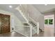 Bright entryway with hardwood floors, a staircase, and a stylish wooden front door at 110 Westchester Way, Alpharetta, GA 30005