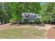 Two-story home with brick accents and mature trees in a lush green setting at 110 Westchester Way, Alpharetta, GA 30005