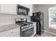 A stainless steel range and refrigerator complement the white cabinetry in this updated kitchen space at 2566 Walden Lake Dr, Decatur, GA 30035