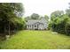 Lush backyard with a green lawn, mature trees, garden furniture and the home's exterior at 1096 Tilden Nw St, Atlanta, GA 30318