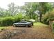 Large backyard with a green lawn, a car parked by the fence, and mature trees at 1096 Tilden Nw St, Atlanta, GA 30318