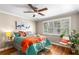 Bright bedroom featuring a ceiling fan, large window with shutters, and colorful bedding at 1990 Wellbourne Dr # 5, Atlanta, GA 30324
