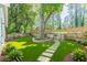 Landscaped backyard with lawn, stone accents, mature trees, and a walking path at 3275 Dodson Dr, East Point, GA 30344