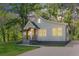 Front exterior view with driveway, grass, mature trees, and professional landscaping at 3275 Dodson Dr, East Point, GA 30344