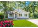 Charming single-Gathering home featuring a manicured lawn, colorful flowers, and inviting front porch at 3275 Dodson Dr, East Point, GA 30344