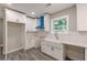 Bright kitchen features white cabinets, a farmhouse sink, gray floors, and a unique blue range hood at 3275 Dodson Dr, East Point, GA 30344