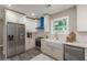 Modern kitchen with white cabinets, stainless steel appliances, farmhouse sink, and blue range hood at 3275 Dodson Dr, East Point, GA 30344