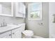 Bathroom with white vanity, toilet, medicine cabinet, and a window at 3650 Croft Nw Pl, Atlanta, GA 30331