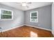 Bright bedroom featuring hardwood floors, a ceiling fan, and natural light from two windows at 3650 Croft Nw Pl, Atlanta, GA 30331