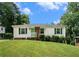 Classic single-story home boasting white siding, a brick foundation, green shutters and a well-maintained front lawn and landscaping at 3650 Croft Nw Pl, Atlanta, GA 30331