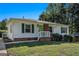 Charming single-story home featuring white siding, brick accents, green shutters and a lush front lawn with mature trees at 3650 Croft Nw Pl, Atlanta, GA 30331