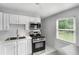 Bright kitchen featuring white cabinets, stainless steel appliances, subway tile backsplash, and a stainless steel sink at 3650 Croft Nw Pl, Atlanta, GA 30331