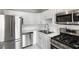 Modern kitchen featuring white cabinets, stainless steel appliances, tiled floors, and a stainless steel sink at 3650 Croft Nw Pl, Atlanta, GA 30331