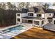 Stunning home backyard featuring a sparkling pool, relaxing hot tub, and landscaped patio for serene outdoor living at 5211 Powers Ferry Rd, Sandy Springs, GA 30327